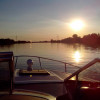 Sunset in calm waters from a boat with small outboard motor